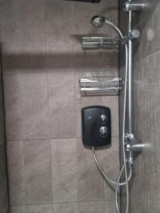 a shower in a bathroom with a soap dispenser at Oakwood in Fleet