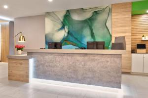 a lobby with a large painting on the wall at Wyndham Garden Anna in Anna +42 photos
