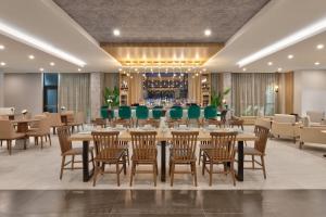 a restaurant with tables and chairs and a bar at Wyndham Garden Anna in Anna