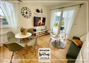 a living room with a table and chairs and a tv at Domeček Jasná in Jeseník