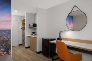 a room with a desk with a mirror and a chair at Wingate by Wyndham Los Alamos in Los Alamos