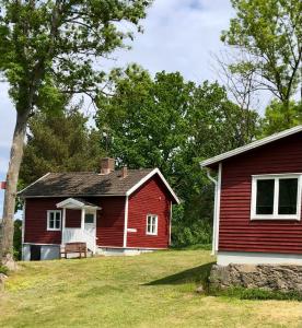 a red house with a bench in front of it at Vätterledens Stugrum in Gränna
