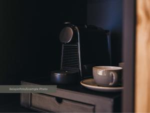 a coffee maker and a cup on a table at VAYA Post Montafon - Neueröffnung Dezember 2026 in Gaschurn