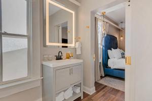 a bathroom with a sink and a mirror and a bed at The Colonial Inn, an Ascend Collection Hotel in Hillsborough +54 photos