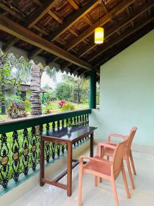a patio with a table and chairs on a balcony at Golden Pearl Beach Resort in Baga