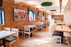 a restaurant with wooden walls and tables and chairs at Familienhotel Löwen in Nesselwang