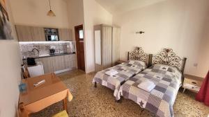 a bedroom with two beds and a kitchen with a sink at Filippos Apartments "Room 5" in Spartià
