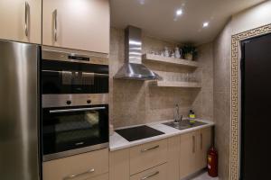 a kitchen with a stainless steel refrigerator and a sink at CENTAURIA Greek Luxury Suite 5' Port Gate 7-8 & Cruises Gate 11-12 in Piraeus +20 photos