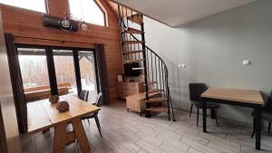 a living room with a spiral staircase and a table at Domki u Ralfiego in Łuka +15 photos