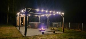a small gazebo with a lit candle in it at night at Domki u Ralfiego in Łuka
