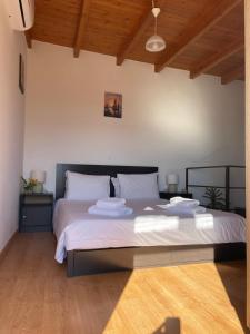 a bedroom with a large bed with towels on it at Tsitsinos maisonette house in Zekros