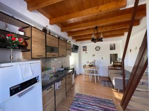 a kitchen with wooden cabinets and a living room at Tsitsinos maisonette house in Zekros