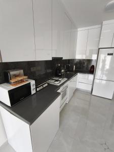 a kitchen with white cabinets and a black counter top at Caesar Resort, Epictetus,Iskele, North Cyprus in Iskele