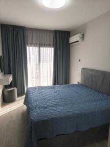 a bedroom with a blue bed and a window at Caesar Resort, Epictetus,Iskele, North Cyprus in Iskele +2 photos