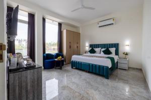 a hotel room with a bed and a television at Yashobhoomi Suites near Yashobhoomi Convention Centre in New Delhi +39 photos