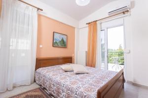 a bedroom with a bed and a large window at Serene Villa in Kriopigi