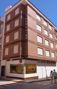 two people walking in front of a building at Apartamentos VeraVibe in Caravaca de la Cruz