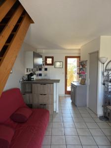 a kitchen with a red couch in a room at La mer en liberté in Gruissan +14 photos