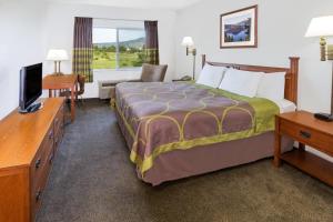 a hotel room with a bed and a television at Super 8 by Wyndham Central Pt Medford in Central Point +23 photos