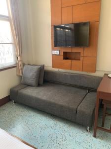 a couch in a room with a flat screen tv at โรงแรมยุติชัย in Prachuap Khiri Khan