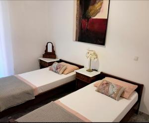 a bedroom with two beds and a lamp and a picture at Parga Center Apartment in Parga