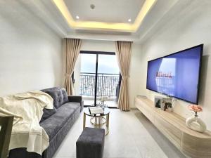 a living room with a couch and a large tv at Lloyd's Daily Suites - SOHO Residence, Bui Vien Walking Street, BenThanh Market & SG's Vibe in Ho Chi Minh City
