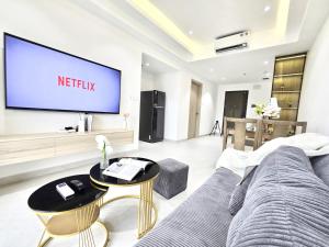 a living room with a couch and a big screen tv at Lloyd's Daily Suites - SOHO Residence, Bui Vien Walking Street, BenThanh Market & SG's Vibe in Ho Chi Minh City