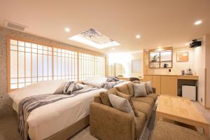 a bedroom with a bed and a couch and a window at HOTELみなと-Minato- 新宿 in Tokyo