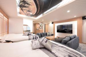 a bedroom with two beds and a living room at HOTELみなと-Minato- 新宿 in Tokyo