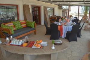a room with a table and a couch and a table and chairs at Maanzoni - Ndoto House ,Athi River by Nest & Nomad in Machakos