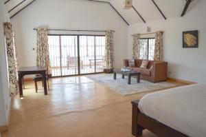 a bedroom with a bed and a couch and a table at Maanzoni - Ndoto House ,Athi River by Nest & Nomad in Machakos +79 photos