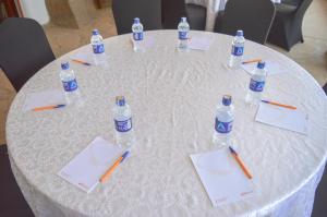 a white table with pens and bottles of water on it at Maanzoni - Ndoto House ,Athi River by Nest & Nomad in Machakos