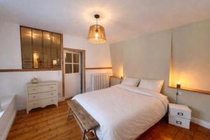 a bedroom with a large white bed and a dresser at Maison de campagne en plein centre de Senlis in Senlis