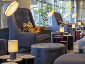 a lobby with chairs and tables and lights at Radisson Blu Hotel, Trondheim Airport in Stjoerdal