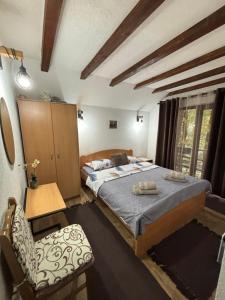 a bedroom with two beds and a chair at Vila KTM Lisine in Despotovac
