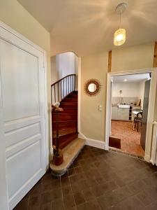 a hallway with a staircase in a home at Maison de campagne en plein centre de Senlis in Senlis