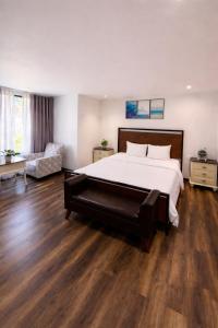 a large bedroom with a large bed and wooden floors at Camly Chic Villa in Da Lat