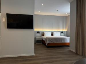 a bedroom with a bed and a flat screen tv at Premier Hotel Miskolc in Miskolc