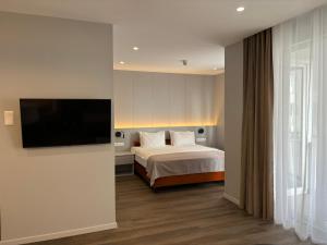a bedroom with a bed and a flat screen tv at Premier Hotel Miskolc in Miskolc