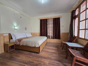 a bedroom with a large bed and a window at Hotel Lady of Keylong in Kyelang