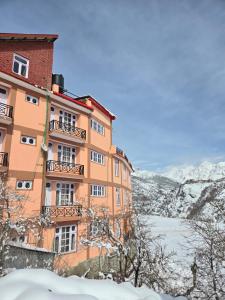 an orange building with snow on the ground at Hotel Lady of Keylong in Kyelang