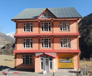 a pink building with a black roof at Hotel Lady of Keylong in Kyelang