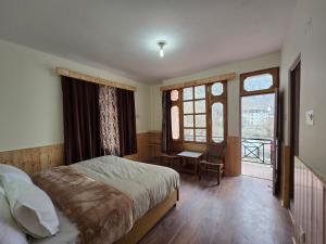 a bedroom with a bed and a large window at Hotel Lady of Keylong in Kyelang