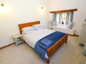 a bedroom with a large bed and a window at Barley Cote Farm in Keighley