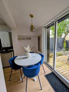 a dining room with a white table and blue chairs at Ma Casa in Boulogne-sur-Mer +21 photos