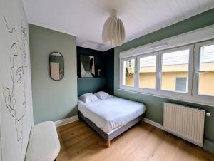 a small bedroom with a bed and a window at Ma Casa in Boulogne-sur-Mer