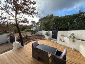 a patio with a table and chairs on a wooden deck at Studio avec double terrasse Roquefort les Pins in Roquefort-les-Pins