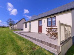 a house with a wooden deck in front of it at Country Cottage in Brecon