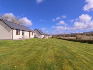 a house with a large grass field in front of it at Country Cottage in Brecon +10 photos