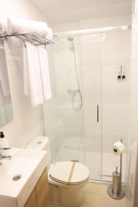 a white bathroom with a shower and a toilet at Apartamentos VeraVibe in Caravaca de la Cruz +59 photos